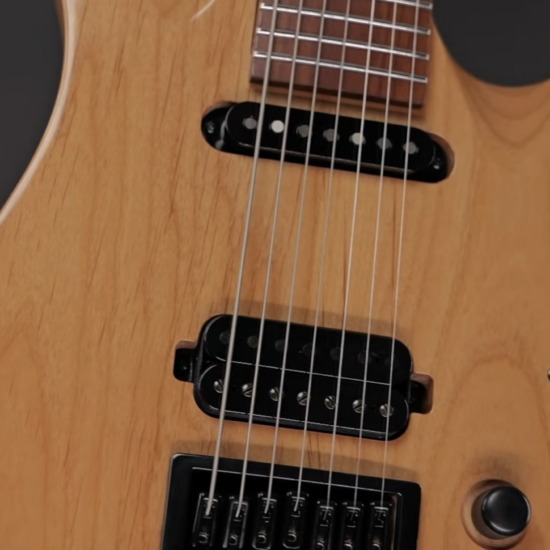 Close-up of the Solar AB1.7ETN 7-string electric guitar showing natural wood finish, black pickups, fixed bridge, and control knob