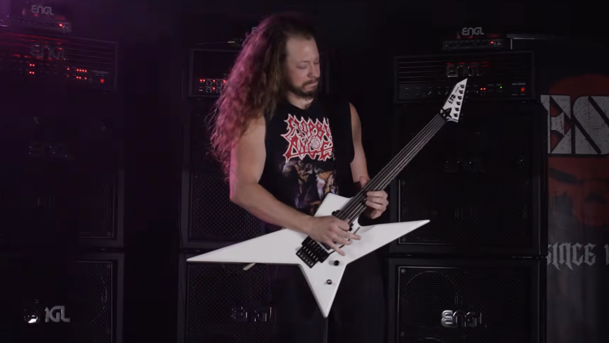 Musician playing an ESP LTD Deluxe RS-1000 white offset electric guitar in front of ENGL amplifier stacks.