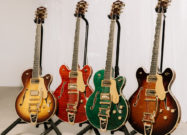 Four Gretsch Broadkaster LX Figured Center Block guitars with String-Thru Bigsby vibrato tailpieces displayed on stands in Havana Burst, Bourbon Stain, Caramel Dawn, and Tropic Aura finishes.