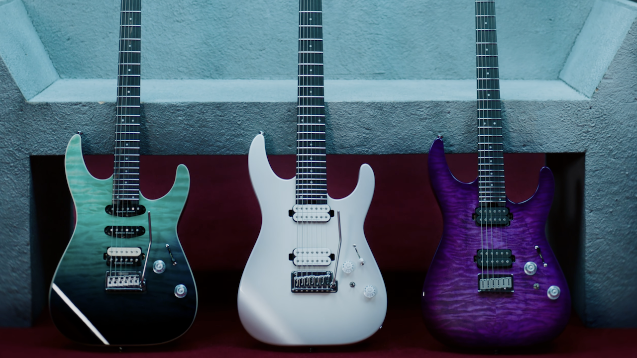 Three Jackson Pro Mod Plus Dinky DK24 electric guitars displayed side by side, featuring teal, white, and purple finishes against a textured wall background.