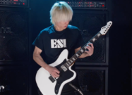 ESP LTD Deluxe XJ-2 HT in white finish played by guitarist onstage in front of stacked ENGL amplifier cabinets, showcasing the guitar’s aggressive offset body shape, reverse headstock, and high-performance modern metal design.