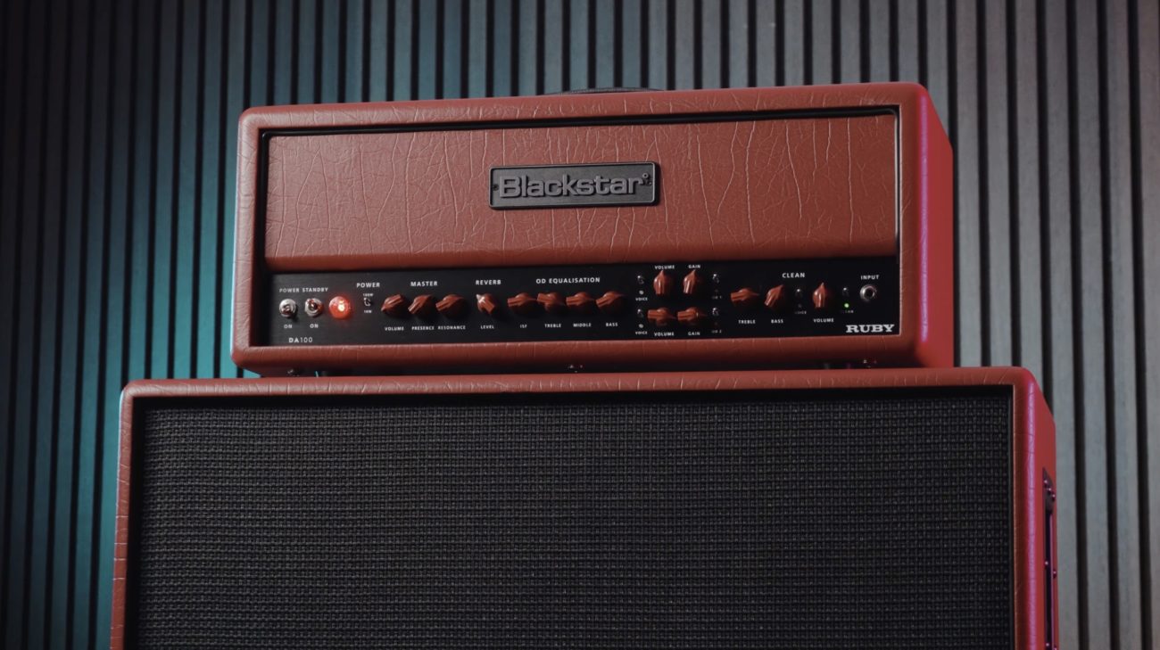 Close-up of the Blackstar DA100 Ruby Doug Aldrich signature 100-watt guitar amplifier head sitting on top of a matching DA412B speaker cabinet with red covering and black grille cloth.