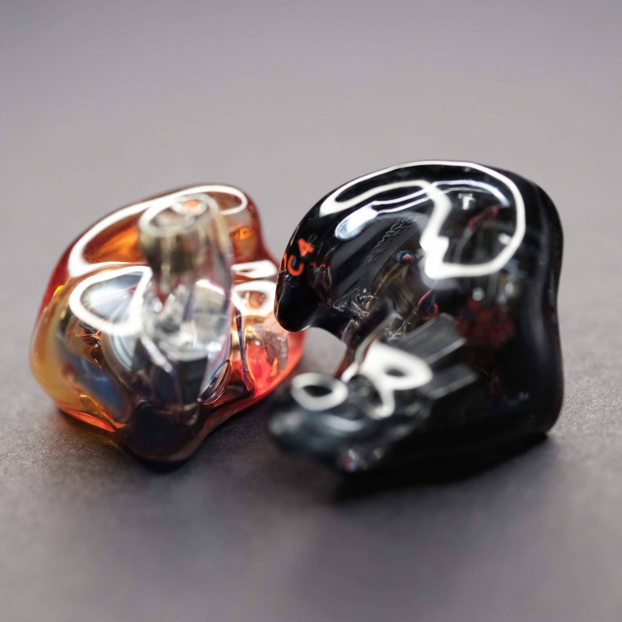 Stealth Sonics C4 custom in-ear monitors in amber and smoke shells, the C9's four-driver sibling