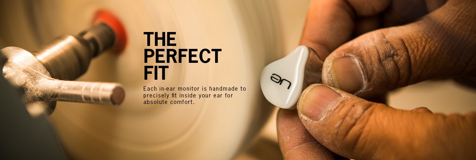 A UE technician hand-finishing a custom in-ear monitor shell